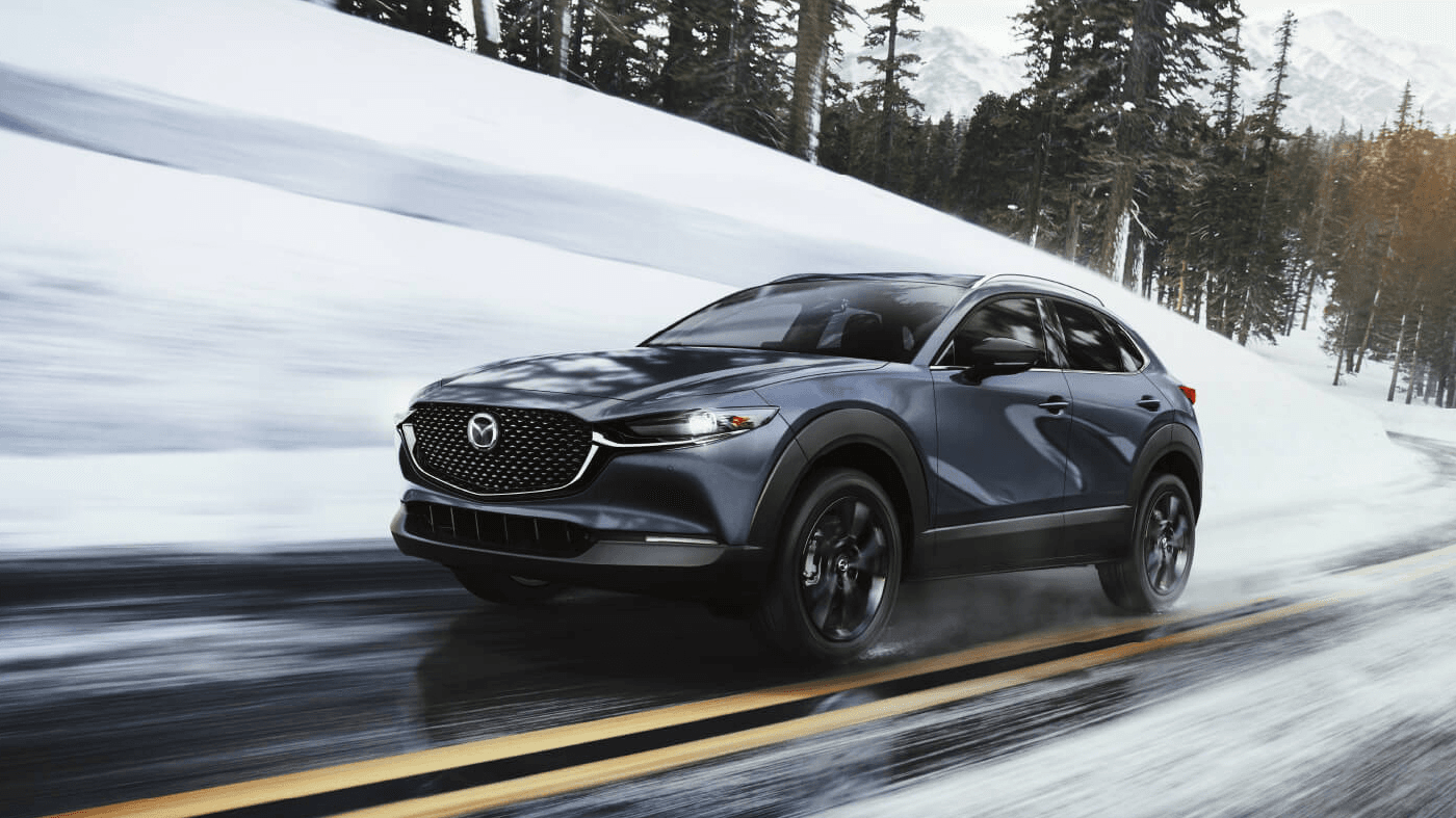 Vue avant et latérale de la Mazda CX-30 2024 sur route enneigé