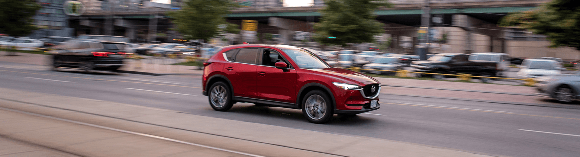 Mazda CX-5 rouge, vu de côté, roulant en ville